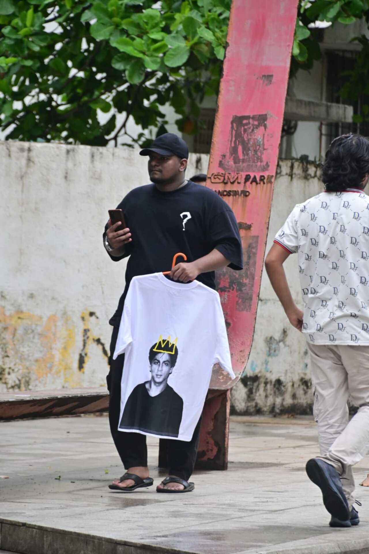The enthusiasm outside Mannat was high with fans holding posters, cakes, banners and even sporting t-shirts with SRK's pictures on them. In this picture a man is seen carrying a similar t-shirt with SRK's picture. 